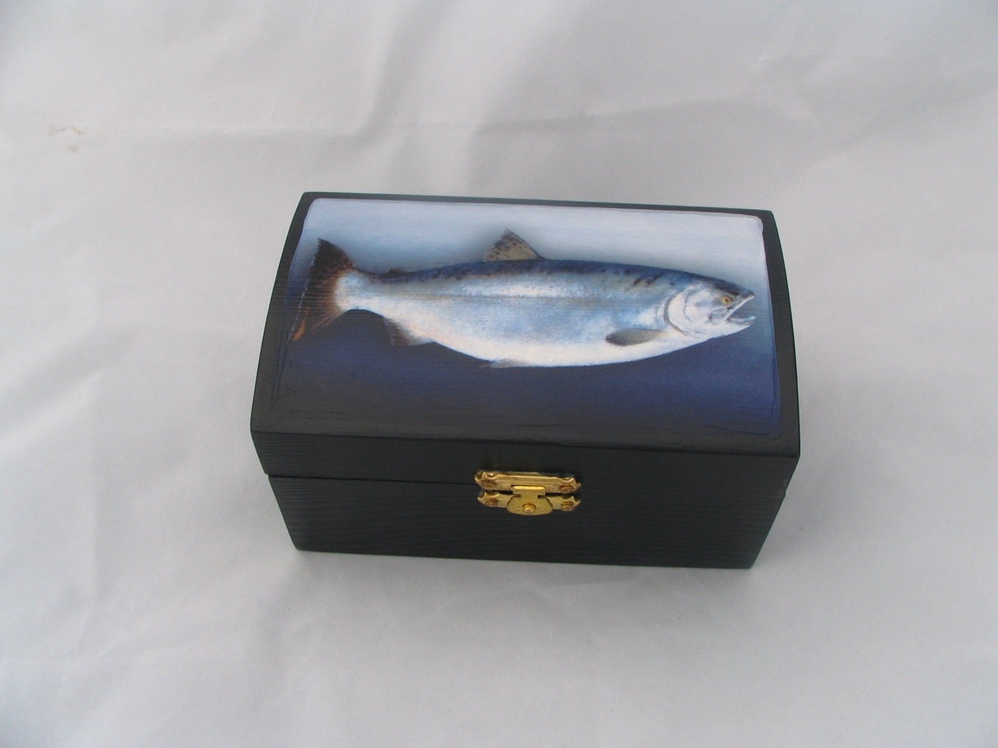Small black hinged box, the lid painted with a single silver salmon against a pale blue and dark ground